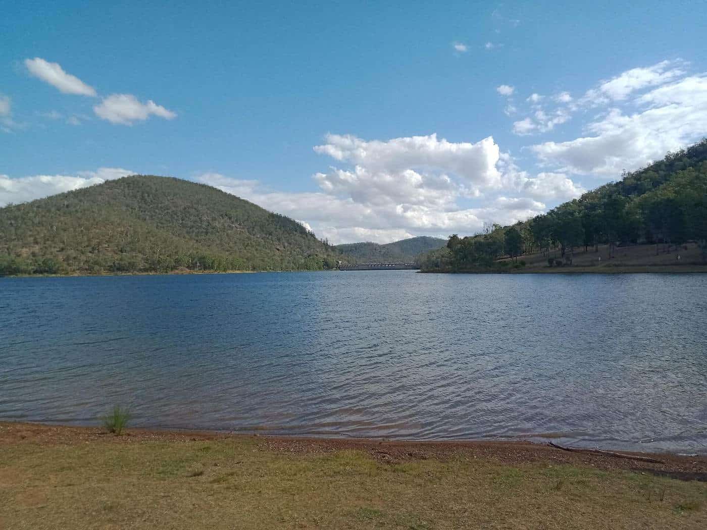 Lake Somerset's broad blue water with forested hills and a bright, cloudy sky